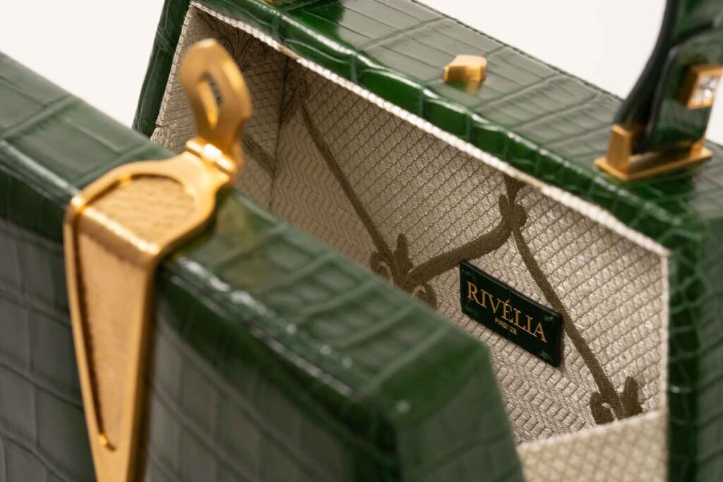 Dettaglio chiusura dorata su pelle coccodrillo Rivelia