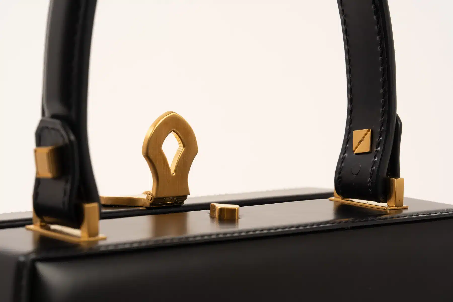 Focus sul manico rigido ed ergonomico della borsa, rifinito in pelle